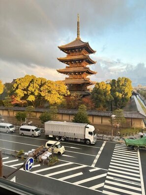 A multi-tiered pagoda with a traditional roof, surrounded by autumn-colored trees. - PREMIUM TOJI (Kyoto)