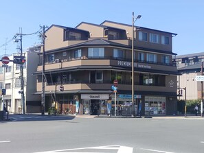 A multi-story building with a 'Premium' sign, a Mini Stop convenience store, and a 'World heritage' sign. - PREMIUM TOJI (Kyoto)