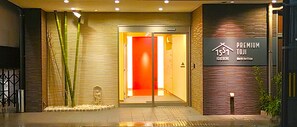 A hotel entrance with a glass door, bamboo plants, and a sign indicating 'Premium Toji' and 'World Heritage.' - PREMIUM TOJI (Kyoto)