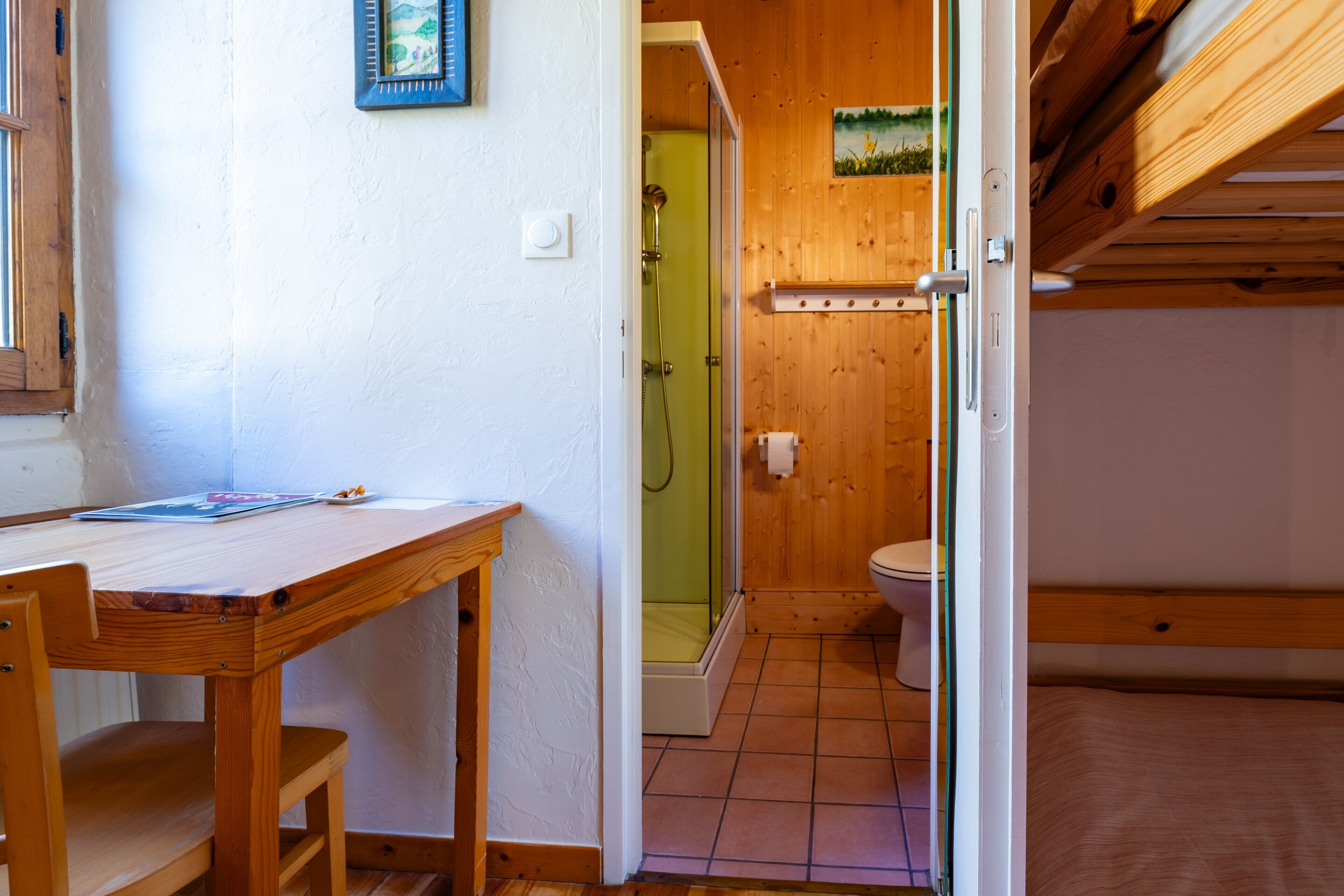 A wooden interior with a wooden table, a shower, and a toilet.
