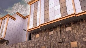 A modern building with a tiled facade and a stone wall. - Al Zaireen 2 (Makkah)