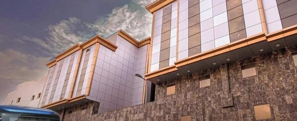 Un bâtiment moderne doté d’une façade recouverte de carreaux et d’un mur en pierre.