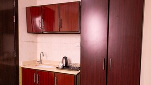 A kitchen with a sink, cabinets, and a kettle. - Al Zaireen 2 (Makkah)