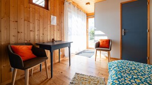 A wooden interior with a bed, a table, and two chairs. - Eco-Lodge Cabin in Ardèche Close to Nature (Saint-Symphorien de Mahun)