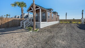 A single-story RV with a covered porch and a fenced yard. - Pet-Friendly Tiny Home with Boat Parking (Rockport)