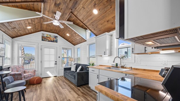 A modern kitchen with white cabinets, a wooden countertop, and a built-in stove. - Pet-Friendly Tiny Home with Boat Parking (Rockport)