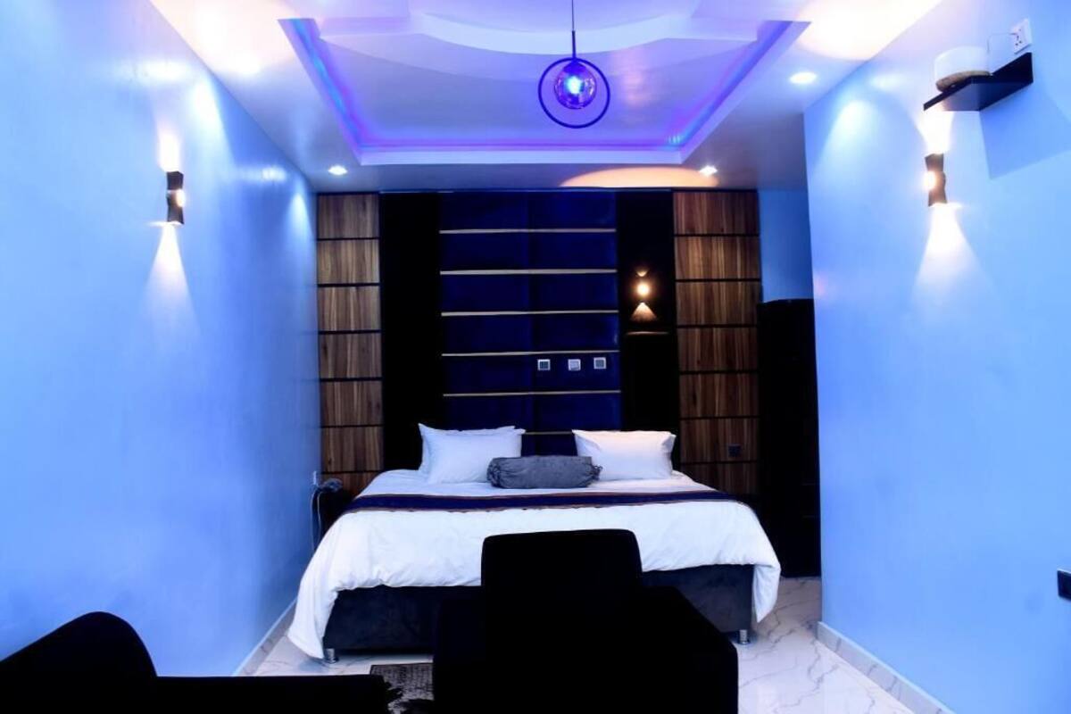 Un dormitorio moderno con una cama grande, estanterías empotradas e iluminación ambiental.
