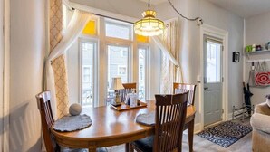 A dining area with a wooden table, chairs, and a chandelier.