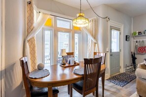 A dining area with a wooden table, chairs, and a chandelier.
