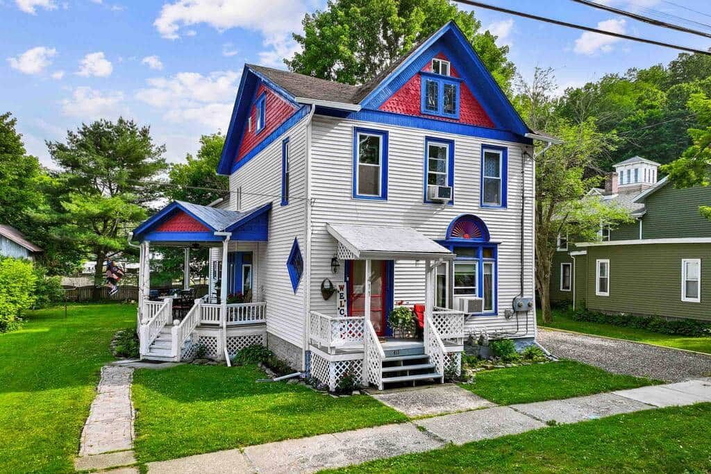 A two-story house with a porch, a front door, and a small front yard.