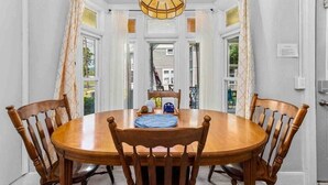 A dining room with a round wooden table, six wooden chairs, a stained glass ceiling light, and a view through the open door. - Sounds of the Waterfall - 1mi to Racetrack & Park (Montour Falls)