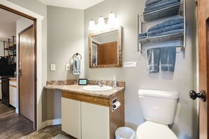 Une salle de bain équipée d’un lavabo, d’un miroir, d’un porte-serviettes et de toilettes.