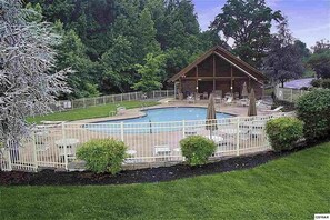 A wooden cabin with a pool and outdoor seating area surrounded by a white fence. - 2 Bedrooms Game Room Hot Tub Dog Friendly (Pigeon Forge)