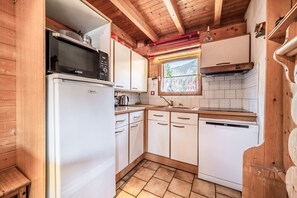 A compact kitchen with a microwave, stove, sink, and dishwasher. - Chalet “6p Classique - Clématite” with Mountain View, Private Terrace & Wi-Fi (Verchaix)