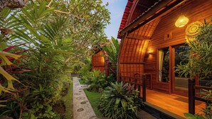 Une maison en bois avec un jardin et un chemin qui mène à l’entrée.