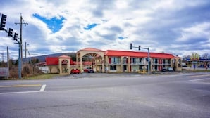 Un motel avec un toit rouge et, au fond, une enseigne McDonald's.