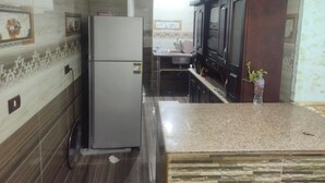 A kitchen with a refrigerator, a sink, and a microwave. - Star House: Steps to Grand Egyptian Museum (Giza Governorate)
