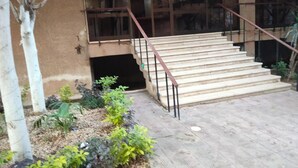 A staircase with metal railings leading to a building entrance. - Star House: Steps to Grand Egyptian Museum (Giza Governorate)