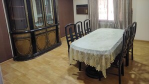 A dining room with a wooden cabinet, a table with chairs, and a window with curtains. - Star House: Steps to Grand Egyptian Museum (Giza Governorate)