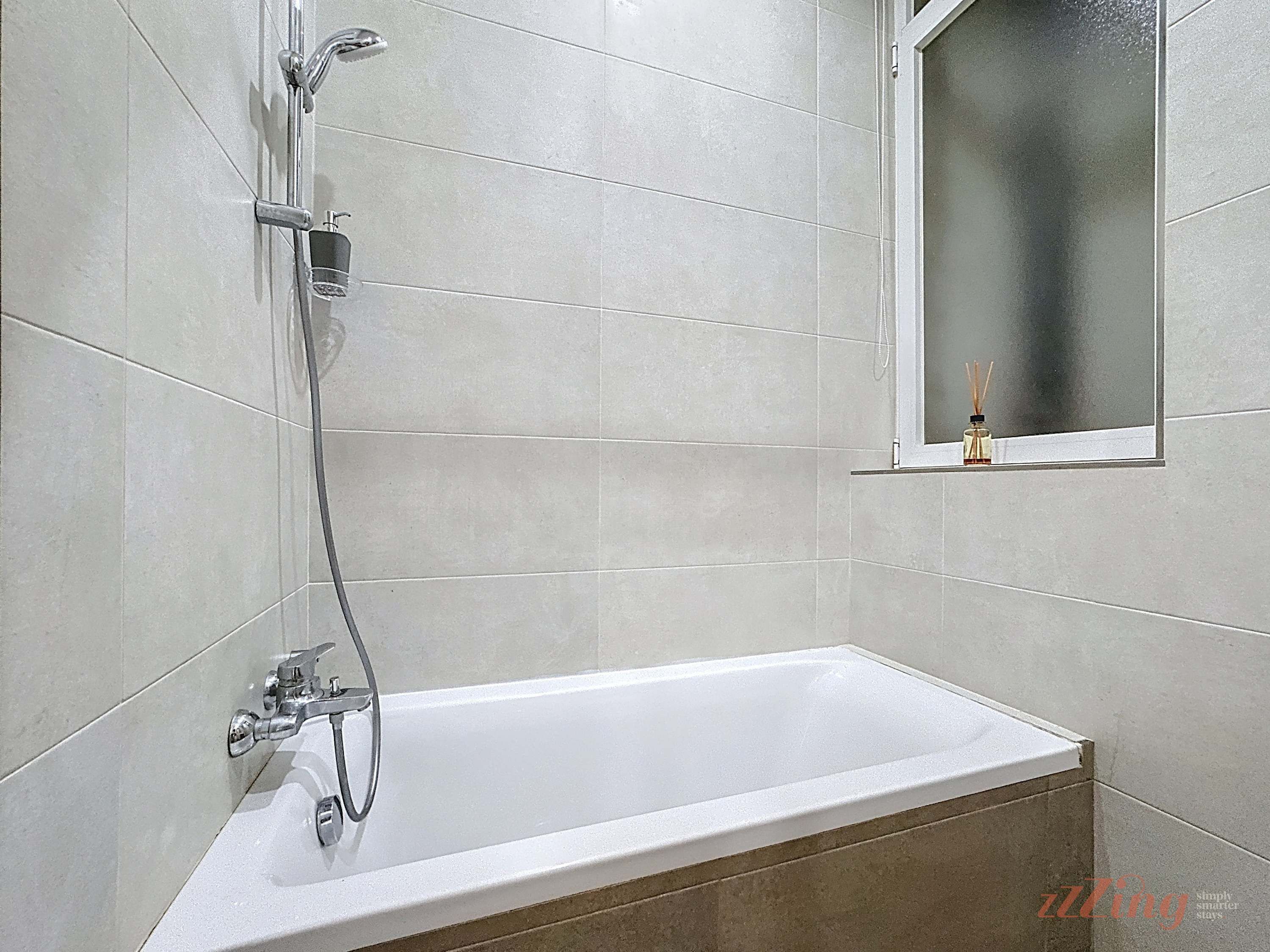 Ein modernes Badezimmer mit einer Badewanne, einer Dusche und einem Fenster mit Blick.