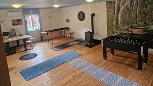 Una habitación con dardos, chimenea, mesa de billar y escritorio con computadora portátil.