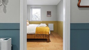 Une chambre à coucher avec un lit, une fenêtre, un radiateur et un téléphone fixé au mur.