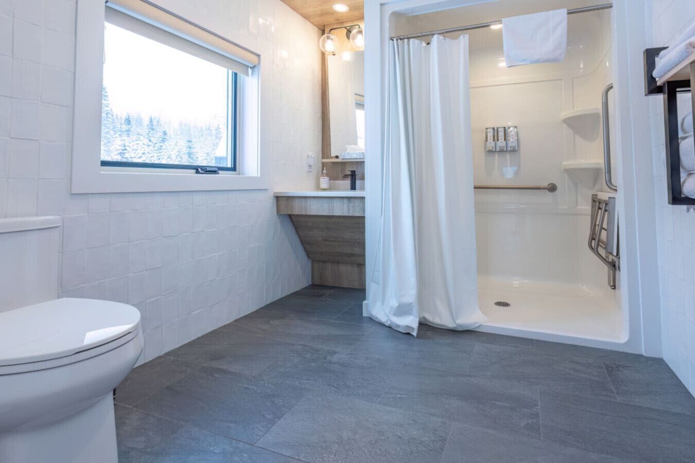 A modern bathroom with a toilet, a shower with a glass door, and a sink.