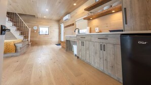 Une cuisine moderne avec des meubles en bois et un réfrigérateur noir.
