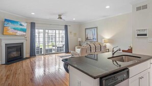 A spacious living room with a fireplace, a dining area, and a kitchen with a large island. - Tastefully FULL furnished, 3 bedrooms with 3.5 bath townhouse. (Rehoboth Beach)
