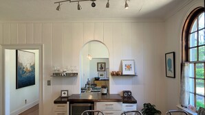 Une cuisine moderne avec des meubles blancs, un îlot central et un coin repas comprenant une table et des chaises.