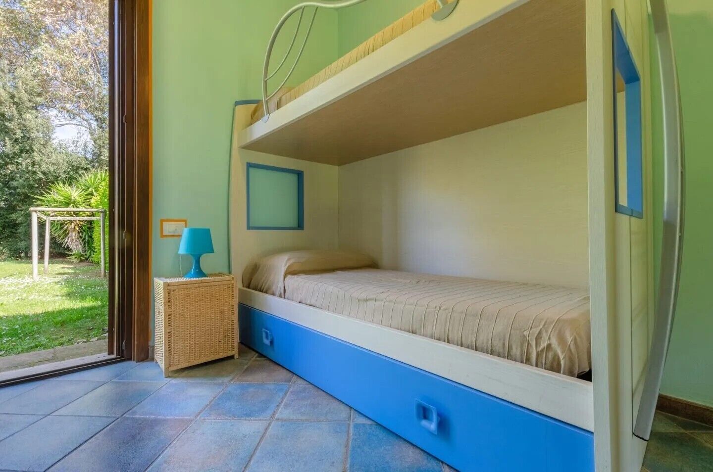 Dormitorio con literas y vista al jardín.