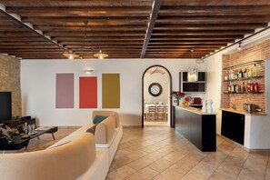 A modern interior with a kitchen area, a dining space, and a seating area with a sofa and chairs. - Villa Le Beringhe 30, Emma Villas (Colle di Val D'Elsa)