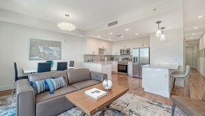 Um apartamento moderno com sala de estar, sala de jantar e cozinha.