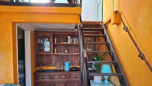 A kitchen with wooden cabinets, a blue kettle, and a staircase leading to an upper level. - StudioAttic | Historic Center | Renovated 2025  | Air Conditioning (Firenze)