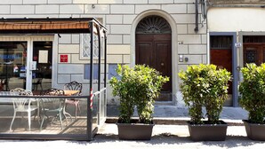 A building with a storefront, outdoor seating, and potted plants. - StudioAttic | Historic Center | Renovated 2025  | Air Conditioning (Firenze)
