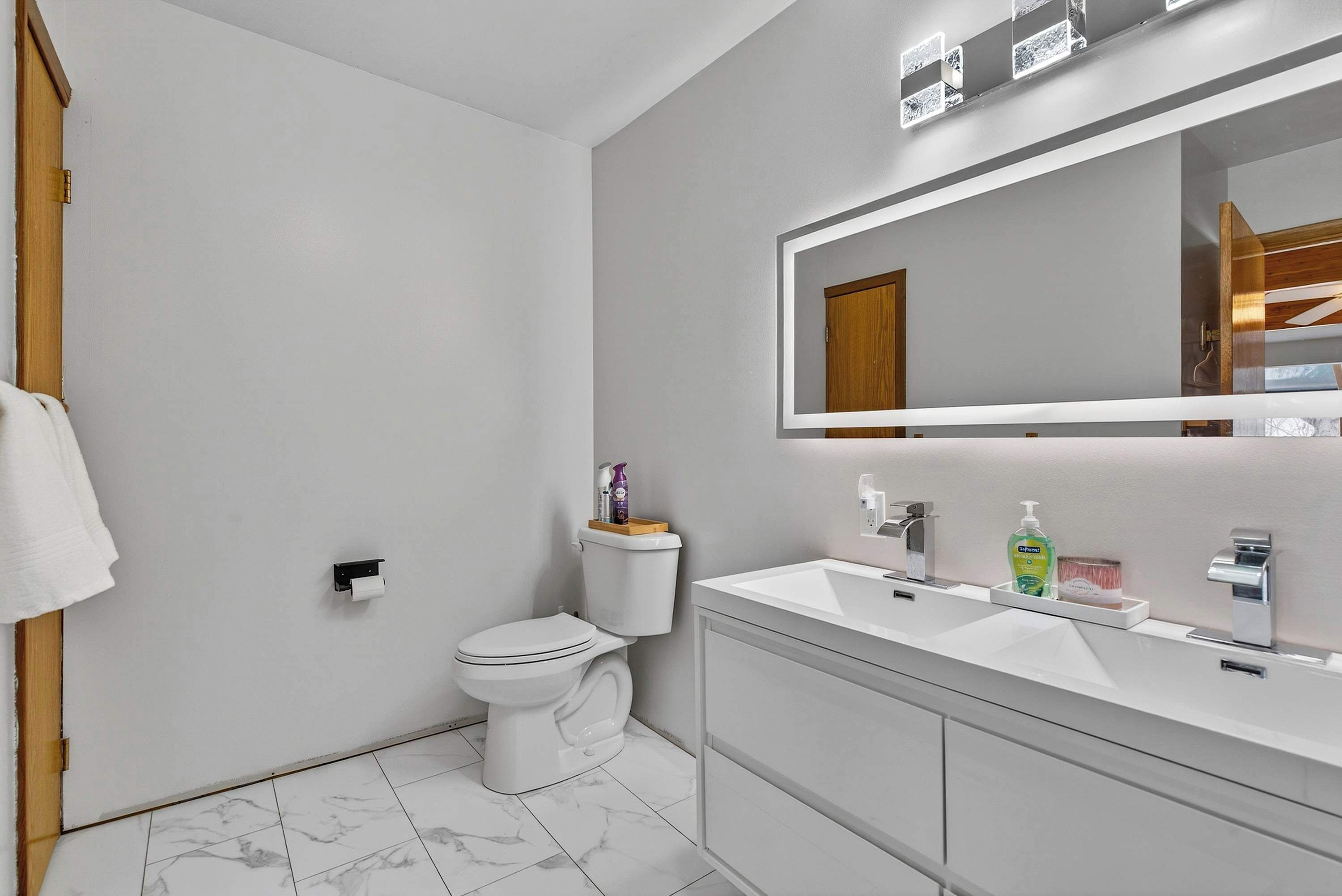 Un bagno moderno con WC, lavandino e specchio.