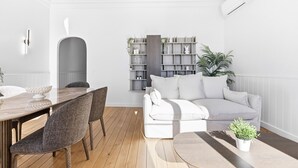 Ein modernes Wohnzimmer mit Essbereich, weißen Wänden und einer eingebauten Bücherreoliste.