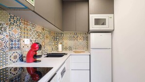 A compact kitchen with a microwave, a red kettle, and a sink. - NEW! House w/HotTub by Douro River & Iconic Bridge (Vila Nova de Gaia)