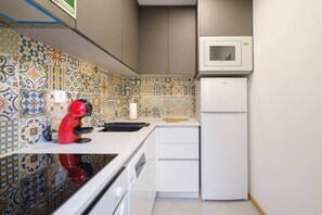 A compact kitchen with a microwave, a red kettle, and a sink. - NEW! House w/HotTub by Douro River & Iconic Bridge (Vila Nova de Gaia)