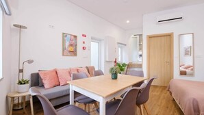 A compact living space with a sofa, a dining table, and a bed. - NEW! House w/HotTub by Douro River & Iconic Bridge (Vila Nova de Gaia)
