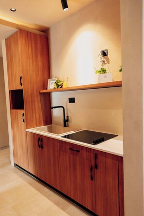A modern kitchen with wooden cabinets, a black faucet, and a built-in microwave.