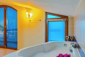 A bathroom with a bathtub, a glass door leading outside, and two glasses of wine on the edge of the tub. - Villa Meltem Luxury Villa with Private Pool & Panoramic Sea Views – Kalkan (Antalya)
