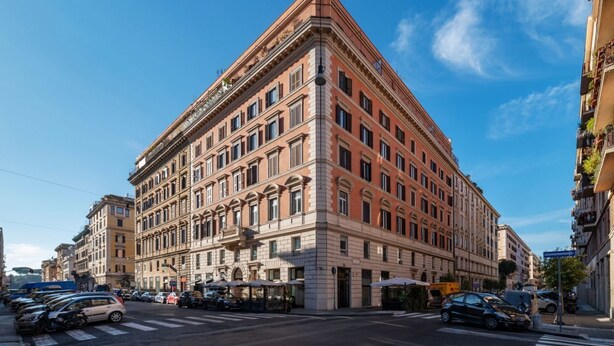 Een groot, historisch pand met een opvallende hoentering, meerdere verdiepingen en een klassieke architectuur.