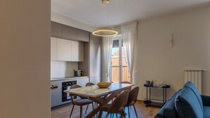 Een moderne keuken met een eettafel, stoelen en een hanglamp.