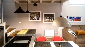 Una cocina moderna con estufa integrada, sillas rojas y una mesa de comedor.