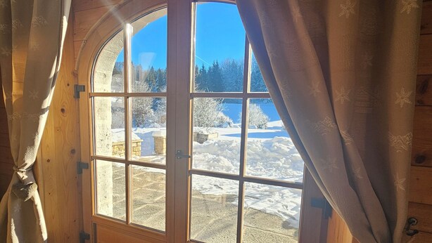 A room with a large arched window, wooden walls, and a tiled floor. - House in the heart of the Jura (Saint-Laurent-en-Grandvaux)