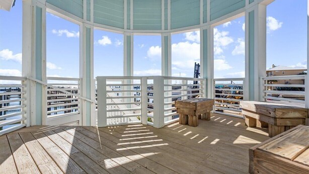 Una terraza techada al aire libre con mobiliario de madera y vista a la ciudad.