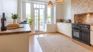 A modern kitchen with a large island, a built-in oven, and pendant lighting. - Hall Gowen, Carnforth (Carnforth)