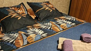 Un lit avec une literie à motifs et deux serviettes enroulées.