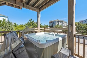 A wooden deck with a hot tub, grill, and seating area, overlooking a residential neighborhood. - Saltwater Pool | Hot Tub | Elevator | Rec Room (Salvo)
